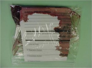 Plastic bag with submission form and sample that leaked dark red fluid.