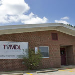 Photo of the red brick TVMDL Poultry Diagnostic Laboratory with a small black mailbox and tree at the entrance