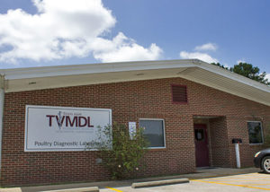 Photo of the red brick TVMDL Poultry Diagnostic Laboratory with a small black mailbox and tree at the entrance