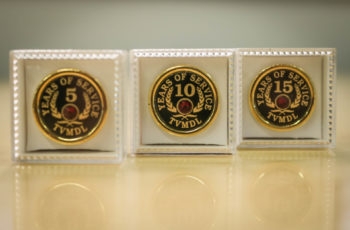 Three gold award pins showing 5, 10, or 25 years of service